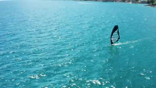 Drohne dreht sich um Person, die auf einem Segelbrett steht. Windsurfen auf dem offenen Meer — Stockvideo