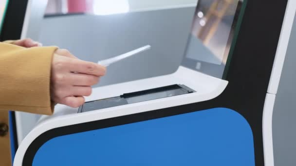 Mujer blanca mano aplicando billete de papel a pantalla de puerta automática en el aeropuerto. Impresión de la tarjeta de embarque en el mostrador de facturación sin contacto antes del vuelo. Escáner de código QR que utiliza en la entrada de la terminal de transporte — Vídeos de Stock