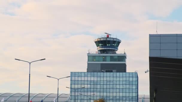 透明なブースで空港管理タワーを機能させます。複数階建てのビルの上にある航空輸送コマンドポスト、青い空の光雲の背景。. — ストック動画