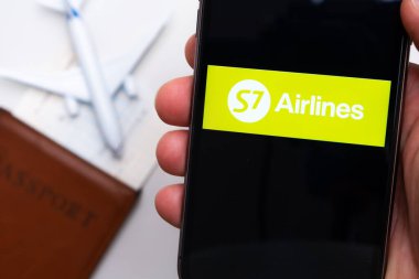 S7 havayolu şirketi uygulaması veya logosu arka planda pasaport, uçuş kartı ve uçak bulunan bir cep telefonunda görüntülendi, Eylül 2021, San Francisco, ABD