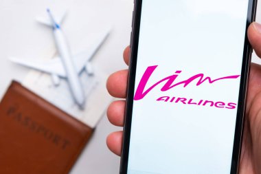 Vim Havayolları uygulaması veya logosu arka planda pasaport, uçuş kartı ve uçak olan bir cep telefonunda sergilendi, Eylül 2021, San Francisco, ABD