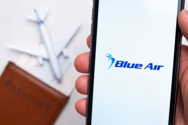 Blue Air Havayolları şirketinin uygulaması veya logosu arka planda pasaport, uçuş kartı ve uçak olan bir cep telefonunda sergilendi, Eylül 2021, San Francisco, ABD