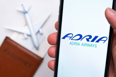 Adria Havayolları şirketinin logosu pasaport, uçuş kartı ve uçak arkaplanındaki cep telefonu ekranında, Eylül 2021, San Francisco, ABD