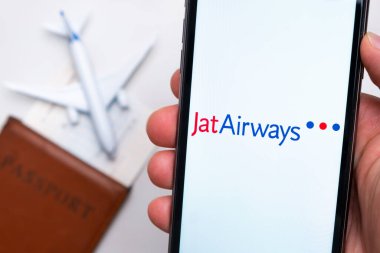 Jat Havayolları uygulaması veya logosu arka planda pasaport, uçuş kartı ve uçak olan bir cep telefonunda sergilendi, Eylül 2021, San Francisco, ABD