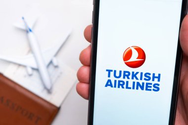 Türk Hava Yolları uygulaması cep telefonunun ekranında, erkeklerin elinde. Pasaport, levrek arka planda beyaz bir uçağın yanında. Kasım 2021, San Francisco, ABD.