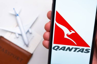 Qantas Havayolları uygulaması cep telefonunun ekranında. Pasaport, levrek arka planda beyaz bir uçağın yanında. Kasım 2021, San Francisco, ABD.