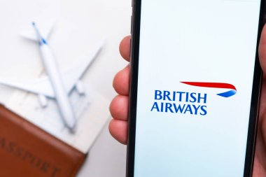 İngiliz Havayolları uygulaması cep telefonunun ekranında. Pasaport, levrek arka planda beyaz bir uçağın yanında. Kasım 2021, San Francisco, ABD.