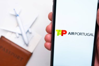 TAP Air Portugal Havayolları mobil uygulaması. Arka planda akıllı telefon, pasaport ve uçuş kartı kullanarak bilet almak için uygun bir cep telefonu uygulaması. Kasım 2021, San Francisco, ABD.