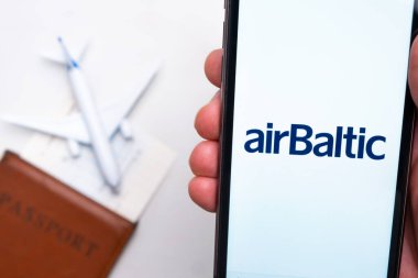 AirBaltic Havayolları mobil uygulaması. Arka planda akıllı telefon, pasaport ve uçuş kartı kullanarak bilet almak için uygun bir cep telefonu uygulaması. Kasım 2021, San Francisco, ABD.