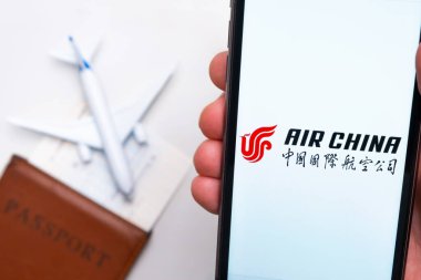 Air China Havayolları uygulaması cep telefonunun ekranında. Pasaport, levrek arka planda beyaz bir uçağın yanında. Kasım 2021, San Francisco, ABD.