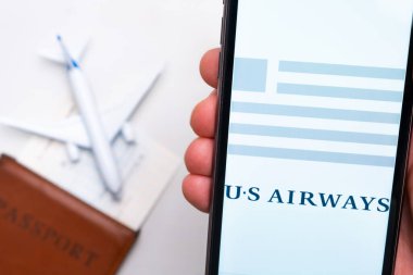 US Havayolları uygulaması cep telefonunun ekranında. Pasaport, levrek arka planda beyaz bir uçağın yanında. Kasım 2021, San Francisco, ABD.