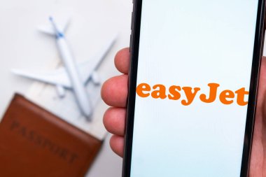 EasyJet Havayolları uygulaması arka planda uçak ve pasaport olan bir akıllı telefon ekranında. Seyahat uygulaması kavramı. Kasım 2021, San Francisco, ABD.