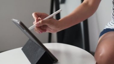 Kadın sanatçı tablet üzerine resim çizmek için özel kalem kullanır