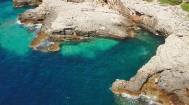 Kıyı kayalıklarında büyük bir mağara ve tatil köyündeki küçük deniz koyunda.