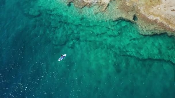 Sportsman πανιά SUP ιστιοσανίδα κατά μήκος της θάλασσας βραχώδη νερά παραλία — Αρχείο Βίντεο