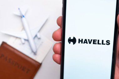 Havells Havayolları uygulaması akıllı telefon ekranında gösteriliyor. Arka planda bulanık bir uçak, pasaport ve biniş kartı var. Kasım 2021, San Francisco, ABD.