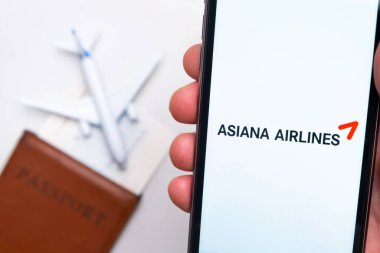 Asiana Havayolları uygulaması arka planında uçak ve pasaport olan bir akıllı telefon ekranında. Seyahat uygulaması kavramı. Kasım 2021, San Francisco, ABD.