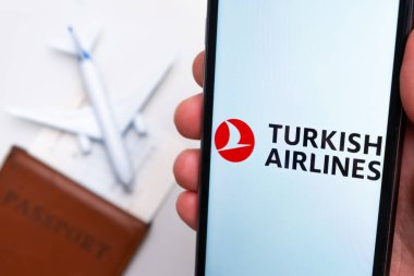 Türk Hava Yolları uygulaması arka planda uçak ve pasaport olan bir akıllı telefon ekranında. Seyahat uygulaması kavramı. Kasım 2021, San Francisco, ABD.