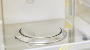 Lastik eldivenli bilim adamını kapatın denge ya da terazi kapısını açın ve numuneleri tartmak için cam bir şişe koyun. Kimyasal ya da ilaç analizi