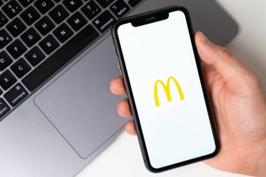 McDonalds akıllı telefondan başvuru açık. Adam elinde bir cep telefonu tutuyor, şirket başvurusu ekranda açık. Güvenli online alışveriş. Kasım 2021, San Francisco, ABD