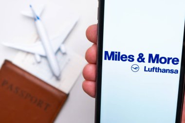 Miles More Lufthansa Havayolları logosu cep telefonu ekranında arka planda uçak, pasaport ve uçuş kartı var. Havayolları mobil uygulaması kavramı. Kasım 2021, San Francisco