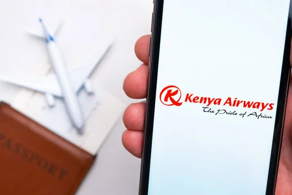 L'application Kenya Airways est affichée sur l'écran du smartphone. Il y a un avion flou, passeport et carte d'embarquement sur le fond. Novembre 2021, San Francisco, États-Unis. — Photo