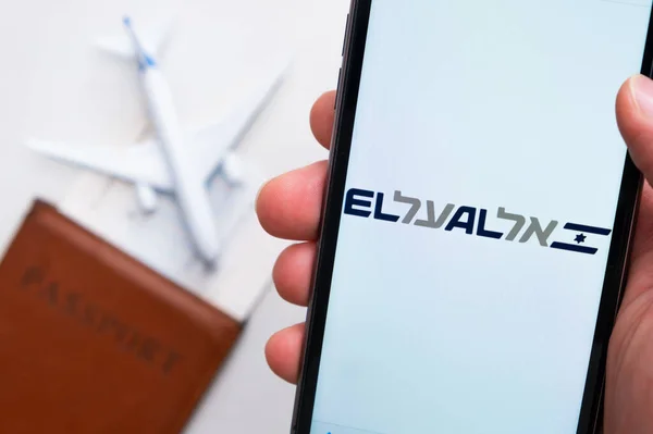 美国旧金山，2021年9月，手机屏幕上的EL AL公司标志手握护照、登机证和飞机背景 — 图库照片