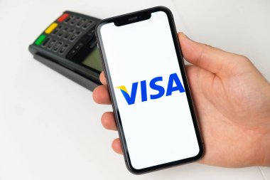 Visa elektronik ödeme sistemi. Mal ve hizmetler için cep telefonu, akıllı telefon ve POS ödeme terminalini kullanarak ödeme yapan bir adam. Kasım 2021, San Francisco, ABD