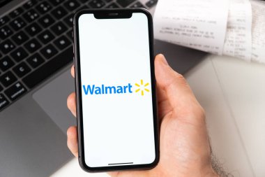 Süpermarketlerin ve market zincirlerinin Walmart mobil uygulaması akıllı telefondan açılır. İnternetten alışveriş yapıyorum. Bir adam akıllı telefon uygulamasında yemek servisi kullanıyor. Kasım 2021, San Francisco