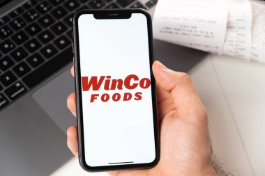 WinCo Gıda süpermarket ve market zincirlerinin mobil uygulaması akıllı telefondan açılır. İnternetten alışveriş yapıyorum. Bir adam akıllı telefon uygulamasında yemek servisi kullanıyor. Kasım 2021, San Francisco