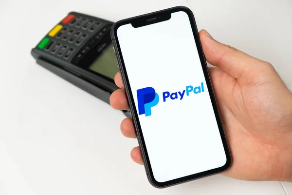 Mobilní aplikace PayPal pro online platbu. Muž používá mobilní telefon s aplikací pro bezpečnou platbu za služby nebo zboží pro bezkontaktní platbu pomocí POS terminálu. Listopad 2021, San Francisco, USA — Stock fotografie