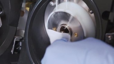 Bilim adamı, iyon kütle spektrometresini ipliksiz bez ve çözücüyle temizliyor. LC Ms QTOF sisteminin bakımı ya da temizlenmesi. Analitik laboratuvarda rutin