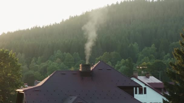 日光の下で山の素晴らしい景色を望む喫煙煙突付きの家の屋根。森の中のコテージで田舎で休息とリラックス. — ストック動画