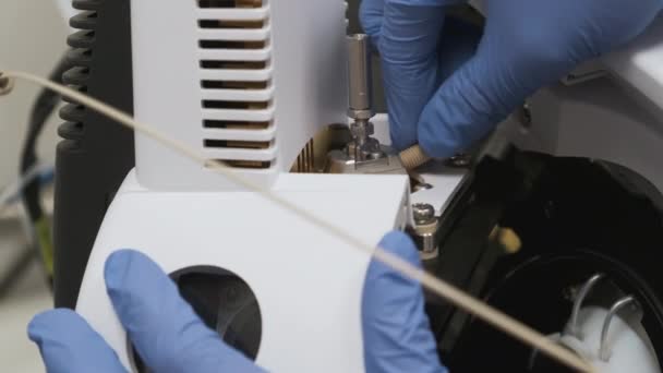 Laboratorní technik odšroubuje kapiláru do jehly nebulizátoru v iontovém zdroji detektoru hmotnosti LC MS qTOF. — Stock video