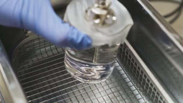 Il lavoratore del laboratorio da vicino mette un bicchiere di vetro in bagno ultrasonico con dettagli in solvente e metallo o ago nebulizzatore dal sistema LC MS. — Video Stock