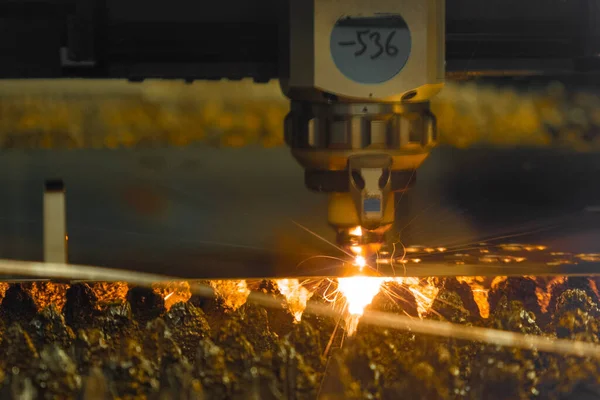 Laserskärare skär tunn metallplåt med gnistor i butiken — Stockfoto