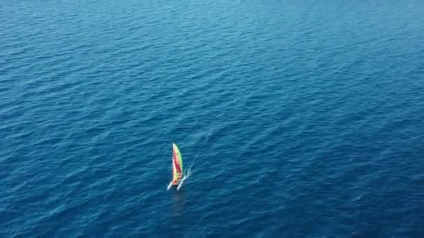 Katamaran segel på azurhavet mot stenig kust på resort — Stockvideo