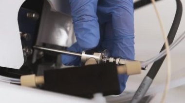 Laboratuvar çalışanı, iyon detektörü kaynağına nebulizör iğnesi yerleştiriyor..
