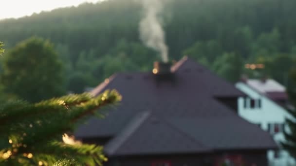 Kouřící komín venkovské chalupy v lesích na pozadí hor — Stock video