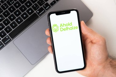 Ahold Delhaize mobil uygulaması akıllı telefon ekranında. Taşınabilir bir uygulama ya da dizüstü bilgisayar kullanarak evde otururken alışveriş yapmak. Akıllı telefon bir erkeğin elinde. Kasım 2021, San Francisco, ABD