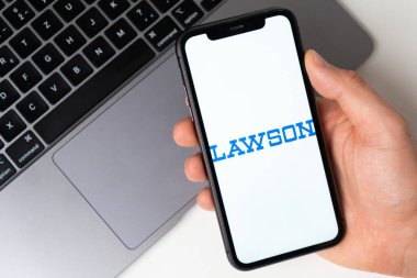 Lawson mobil uygulaması akıllı telefon ekranında. Taşınabilir bir uygulama ya da dizüstü bilgisayar kullanarak evde otururken alışveriş yapmak. Akıllı telefon bir erkeğin elinde. Kasım 2021, San Francisco, ABD