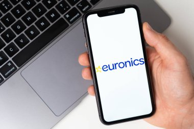Akıllı telefon ekranında Euronics mobil uygulaması. Taşınabilir bir uygulama ya da dizüstü bilgisayar kullanarak evde otururken alışveriş yapmak. Akıllı telefon bir erkeğin elinde. Kasım 2021, San Francisco, ABD