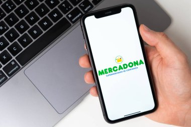 Mercadona, akıllı telefondan başvuru açık. Adam elinde bir cep telefonu tutuyor, şirket başvurusu ekranda açık. Güvenli online alışveriş. Kasım 2021, San Francisco, ABD