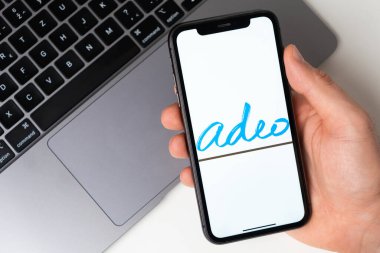 Akıllı telefon ekranında Adeo mobil uygulaması. Taşınabilir bir uygulama ya da dizüstü bilgisayar kullanarak evde otururken alışveriş yapmak. Akıllı telefon bir erkeğin elinde. Kasım 2021, San Francisco, ABD