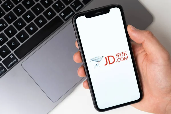 JD Jingdong Mall la aplicación está abierta en el teléfono inteligente. El hombre está sosteniendo un teléfono móvil en su mano, la aplicación de la empresa está abierta en la pantalla. Compras en línea seguras. Noviembre 2021, San — Foto de Stock