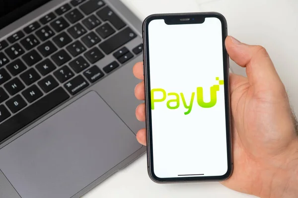 PayU οικονομική πλατφόρμα για μεταφορά χρημάτων χρησιμοποιώντας smartphone. Άντρας χέρι κρατώντας το κινητό τηλέφωνο με εφαρμογή στην οθόνη και σημειωματάριο στο παρασκήνιο. Νοέμβριος 2021, Σαν Φρανσίσκο, ΗΠΑ — Φωτογραφία Αρχείου