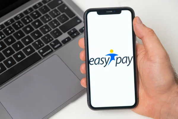 Easy Pay finanční platforma pro převod peněz pomocí smartphonu. Muž drží mobilní telefon s aplikací na obrazovce a notebook na pozadí. Listopad 2021, San Francisco, USA — Stock fotografie