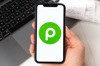 Apple iPhone ekranındaki uygulamayı erkek eli ve dizüstü bilgisayarla arka planda yayınlayın. Çevrimiçi alışveriş kavramı Kasım 2021, San Francisco, ABD