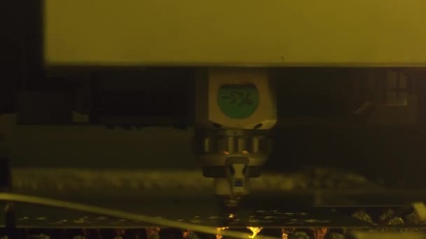 Laser cutter machine cuts thin metal sheet with bright sparks at the manufacture — Video