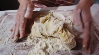 Baker kneads fresh dough for gingerbread on floured table